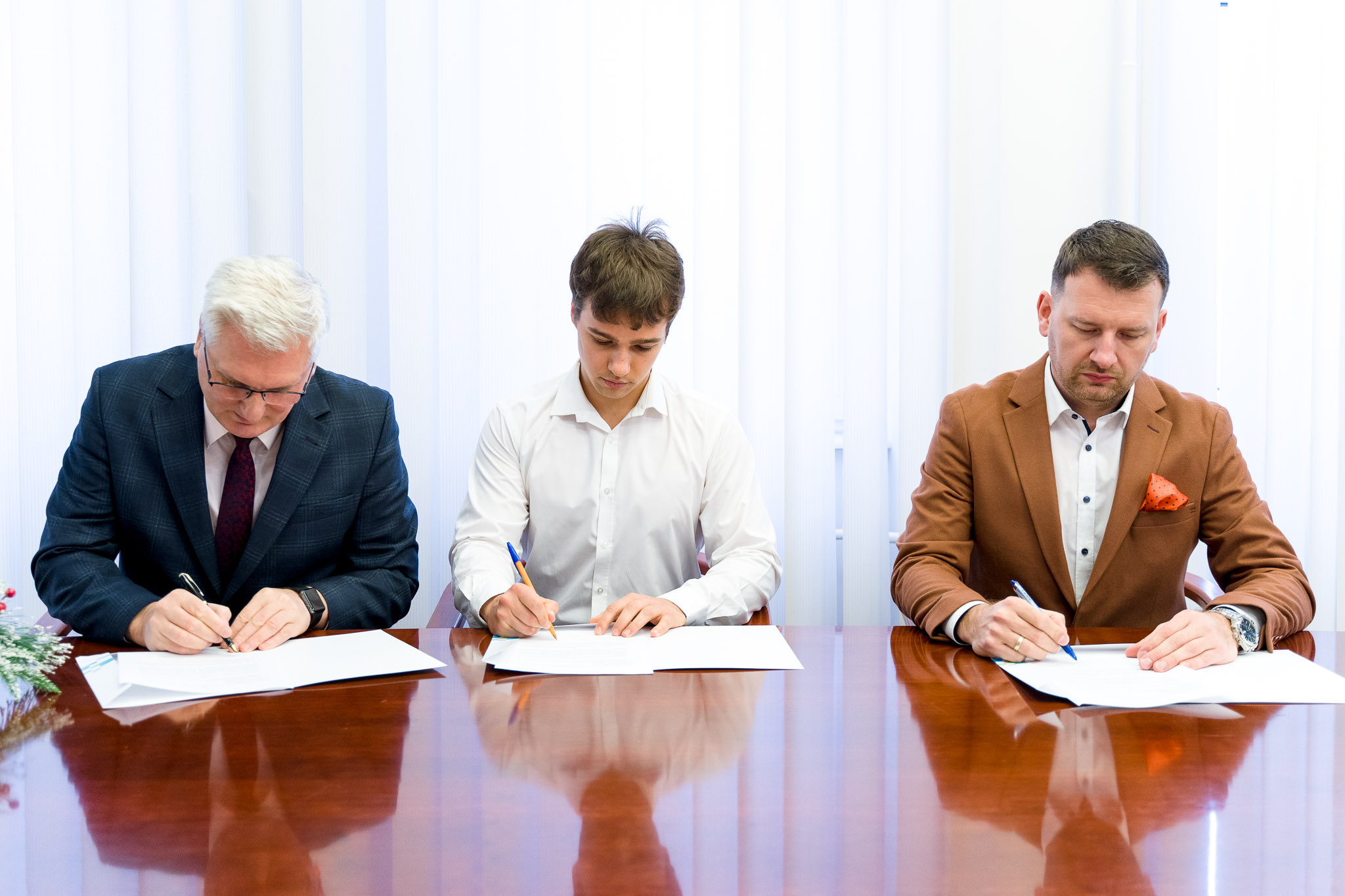 Student Tomasz Chojnowski podczas podpisywania umowy stypendialnej, Rektor dr hab. Dariusz Surowik oraz Prezes Zarządu Banku Piotr Kaczyński