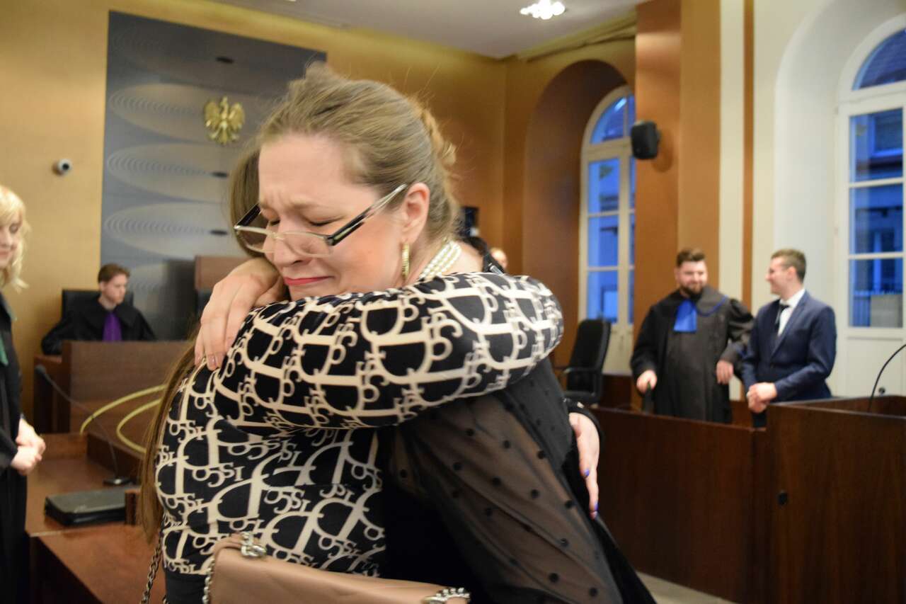 W sali sądowej dwie kobiety przytulają się po ogłoszeniu wyroku
