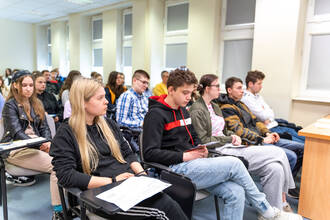 azdjęcie przedstawia grupę uczniów w sali wykładowej