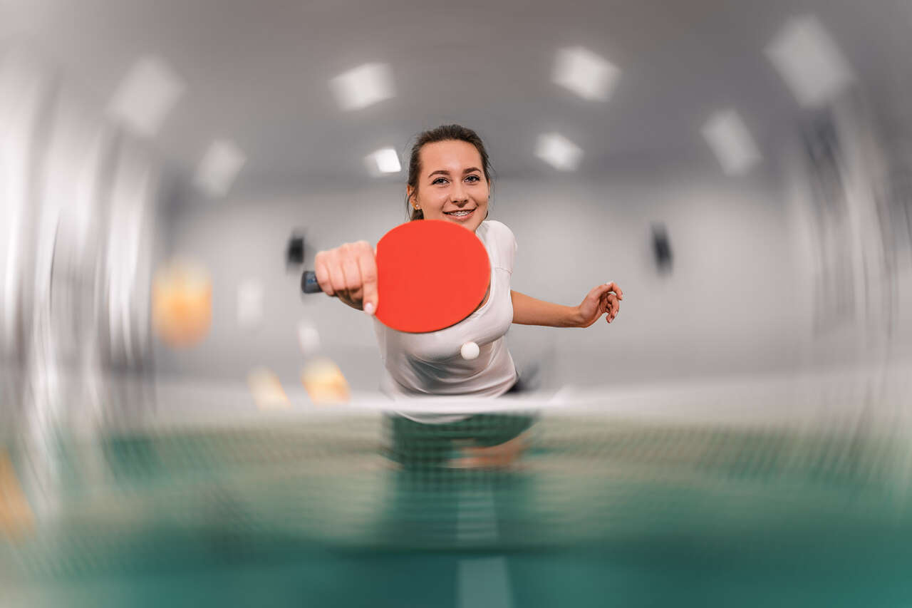 zdjęcie przedstawia młodą kobietę grającą w tenisa stołowego